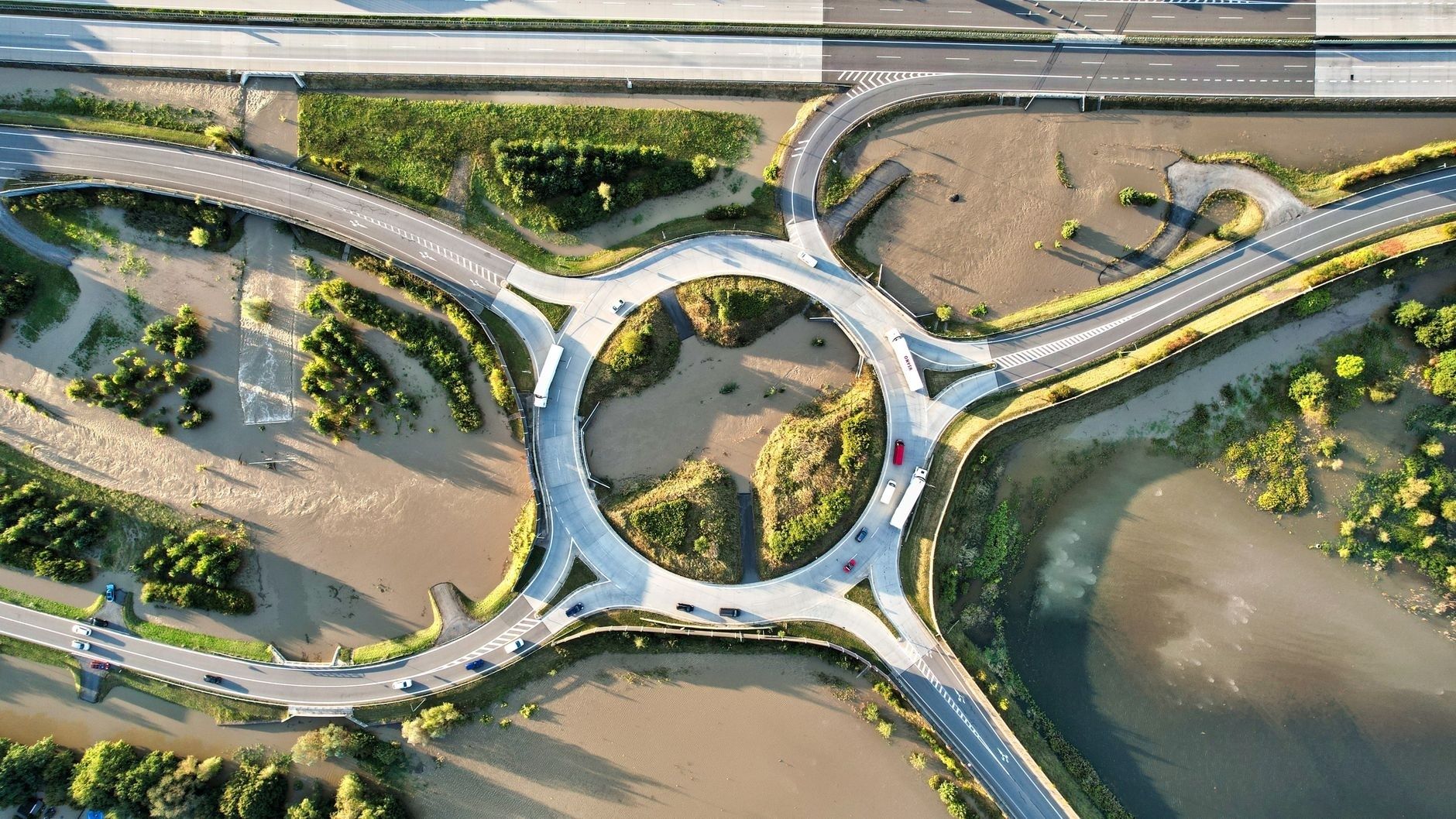 Aerial view of a freeway interchange surrounded by floodwater and vegetation